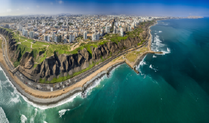 Fotografía aérea panorámica de los acantilados de la Costa Verde en Miraflores, mostrando los edificios de la ciudad frente al Océano Pacífico.
